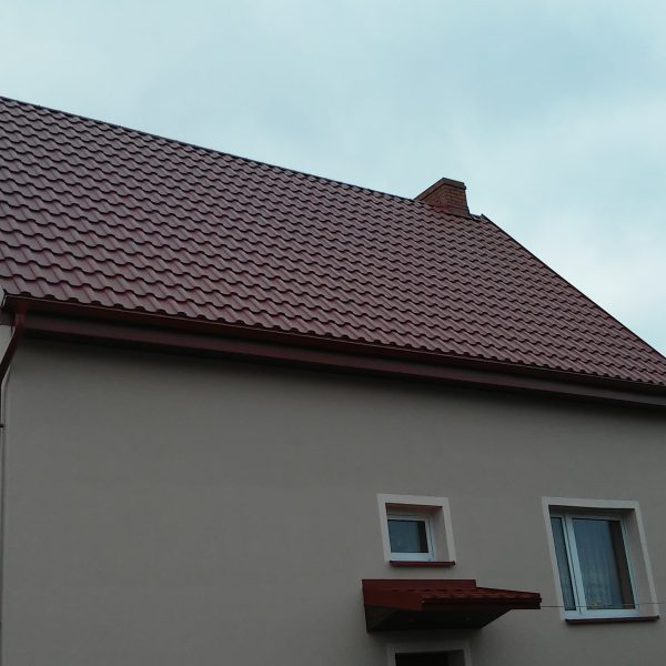 Dach pokryty blachodachówką Ruukki Adamante Purex w eleganckim, wiśniowym odcieniu.