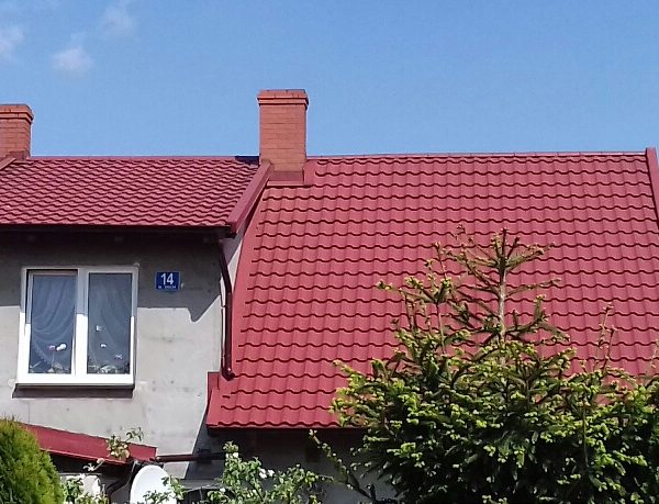 Dach pokryty blachodachówką Ruukki Finnera w eleganckim, wiśniowym odcieniu.