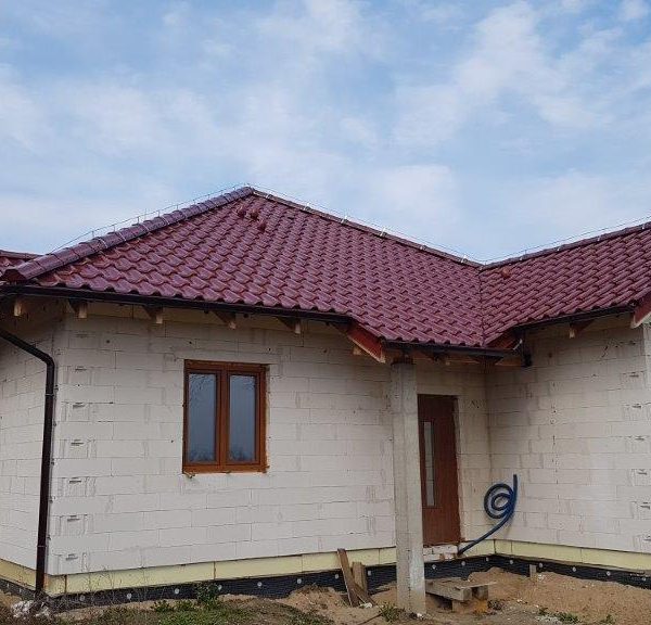 Nowoczesny dom z dachem czterospadowym pokrytym dachówką Creaton Titania kasztan glazura