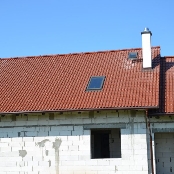 Dach pokryty dachówką Braas Bałtycka w kolorze kasztanowym – trwałe i estetyczne rozwiązanie dachowe dla domu jednorodzinnego.