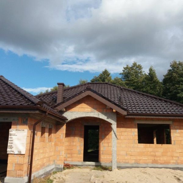 Dach pokryty dachówką Creaton Titania w brązowej glazurze, o eleganckim, lśniącym wykończeniu.