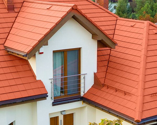 Estetyczna realizacja z płaską dachówką Creaton Kapstadt na dachu czterospadowym.