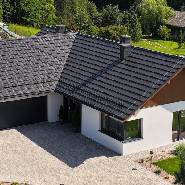 Budynek z wielospadowym dachem z dachówki Creaton Koda w kolorze czarnym, ujęcie panoramiczne