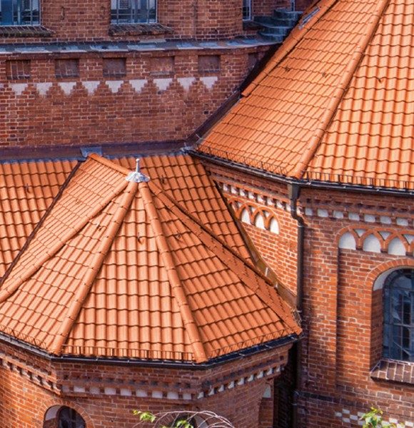 Zamek z wielospadowym dachem pokrytym dachówką ceramiczną Creaton Melodie w kolorze naturalnej czerwieni