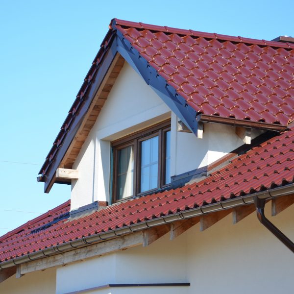 Dach domu pokryty dachówką Creaton Symfonie w kolorze czerwonym winno-bordowym – ponadczasowe rozwiązanie dla tradycyjnej architektury.