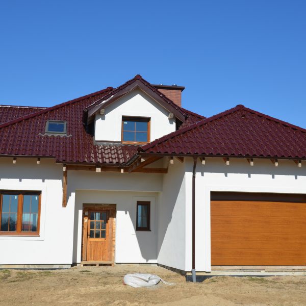 Klasyczna dachówka Creaton Symfonie w barwie czerwieni winnej na nowym budynku – elegancka forma i odporność na warunki atmosferyczne.