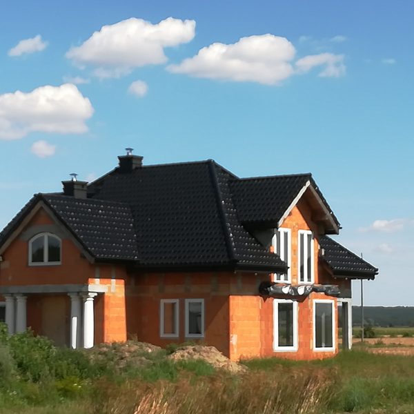 Dach pokryty dachówką Creaton Premium w eleganckiej czarnej glazurze o lśniącym wykończeniu.