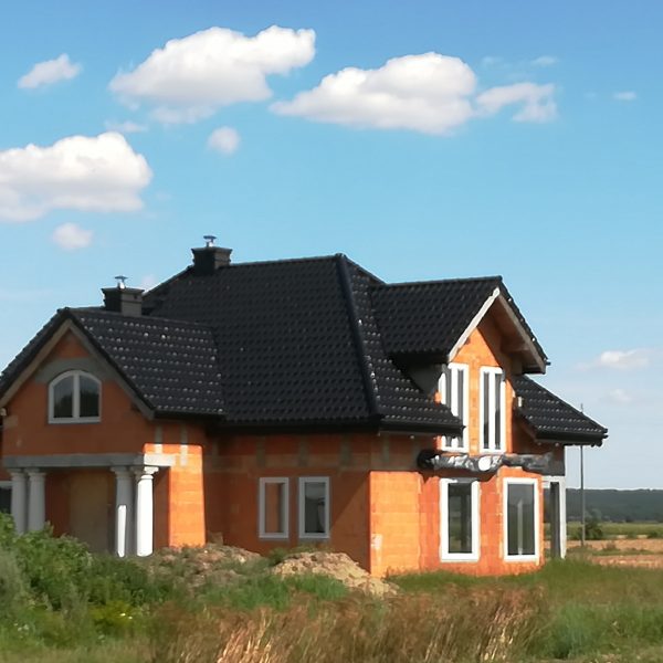 Dach pokryty dachówką Creaton Premium w eleganckiej czarnej glazurze o lśniącym wykończeniu.