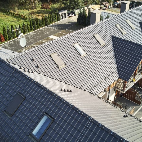 Realizacja obszernego dachu z połyskującą dachówką ceramiczną Röben Piemont titan szara
