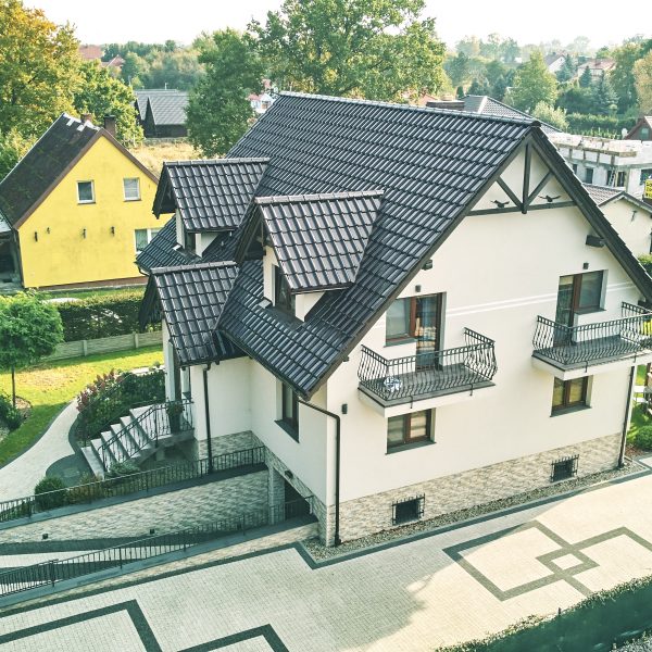 Widok z powietrza na elegancki dach z dachówki Creaton Titania w brązowej glazurze.