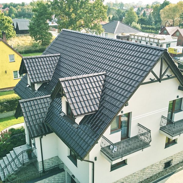 Perspektywa z drona ukazująca dach z dachówki Creaton Titania brąz glazura o lśniącej powierzchni.