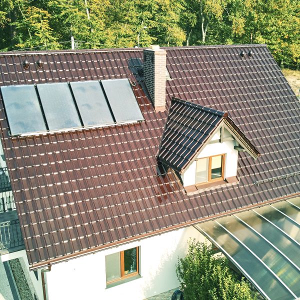 Widok z lotu ptaka na dach z dachówki Creaton Titania brąz glazura, harmonizującej z elewacją.