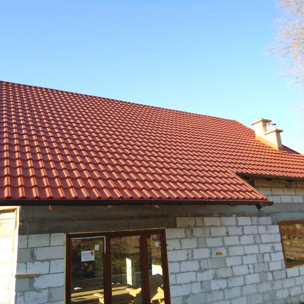 Ceglasty dach z blachodachówki Ruukki Finnera na domu w stanie surowym – przykład wykończenia dachu