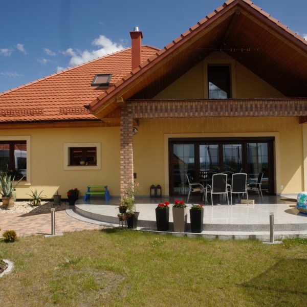 Dach z dachówki Wienerberger karpiówka Natura na domu z jasną, żółtą elewacją i podcieniem tarasowym
