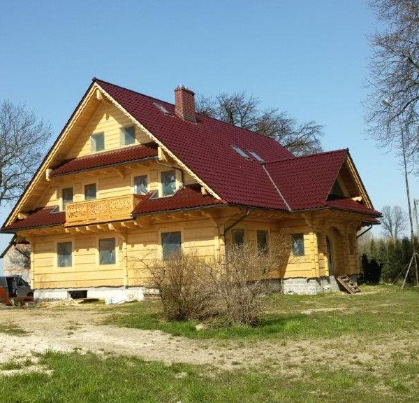 Drewniany dom z dachem z dachówki ceramicznej Creaton Sinfonie w kolorze czerwieni winnej, wykończenie glazurowane
