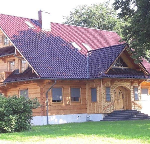 Creaton Sinfonie czerwień winna glazura – eleganckie pokrycie dachowe na budynku z drewna
